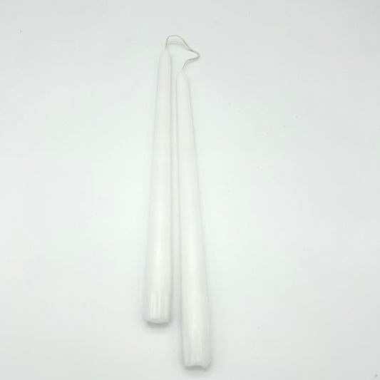 Two white candles on a light gray background