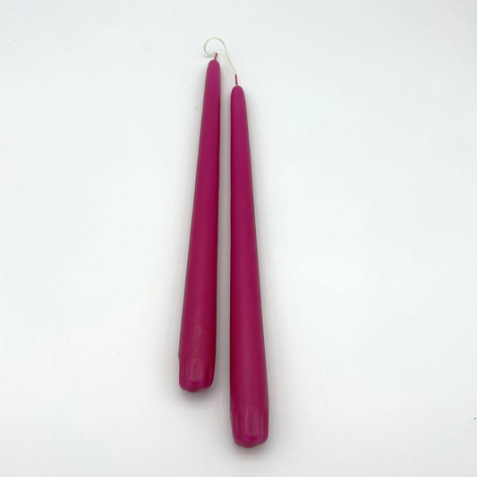 Two pink candles on a white background