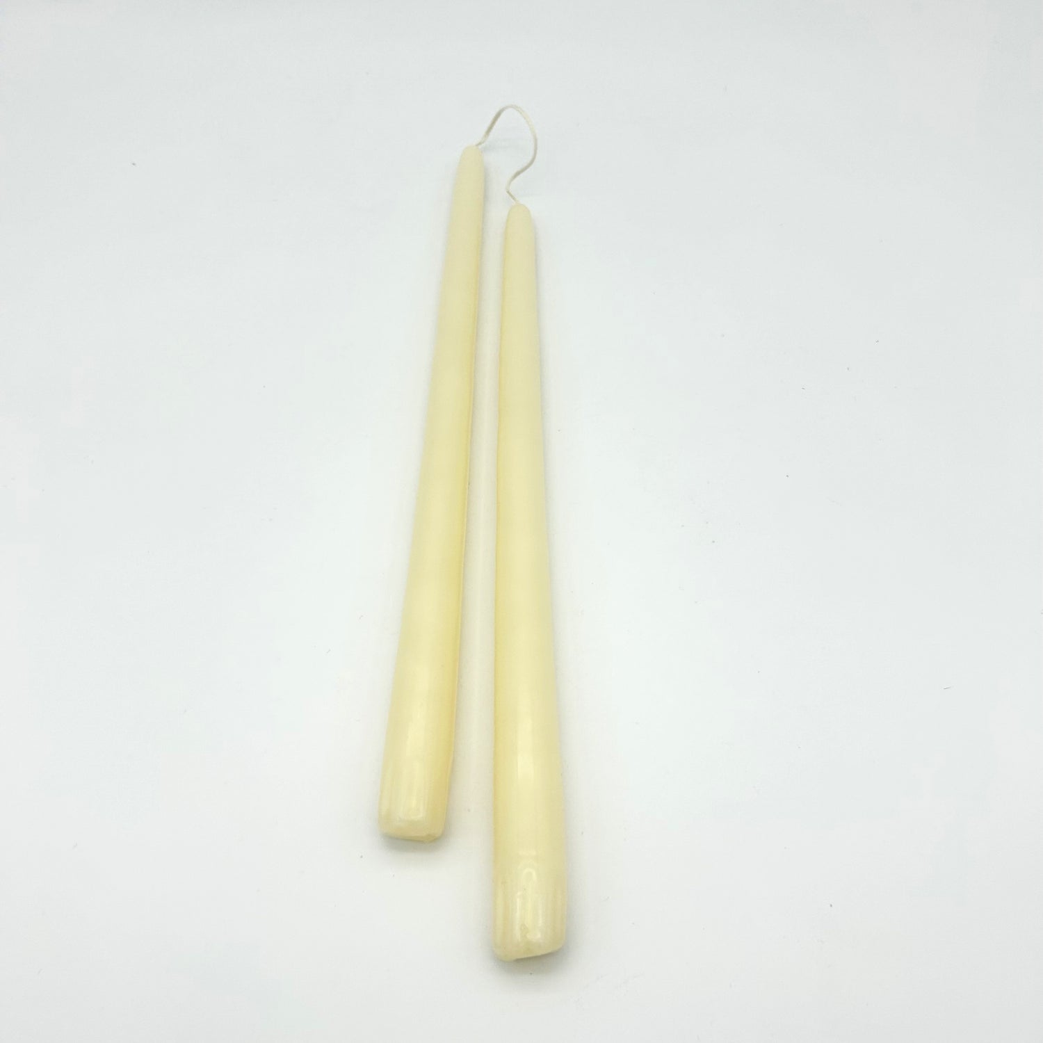 Two beige candles on a white background